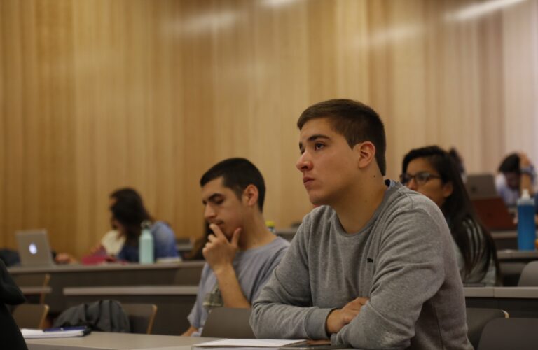 Hombre concentrado en medio de una sala de clases.
