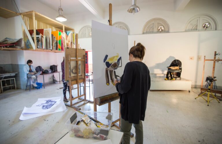 Mujer pintando en un lienzo.
