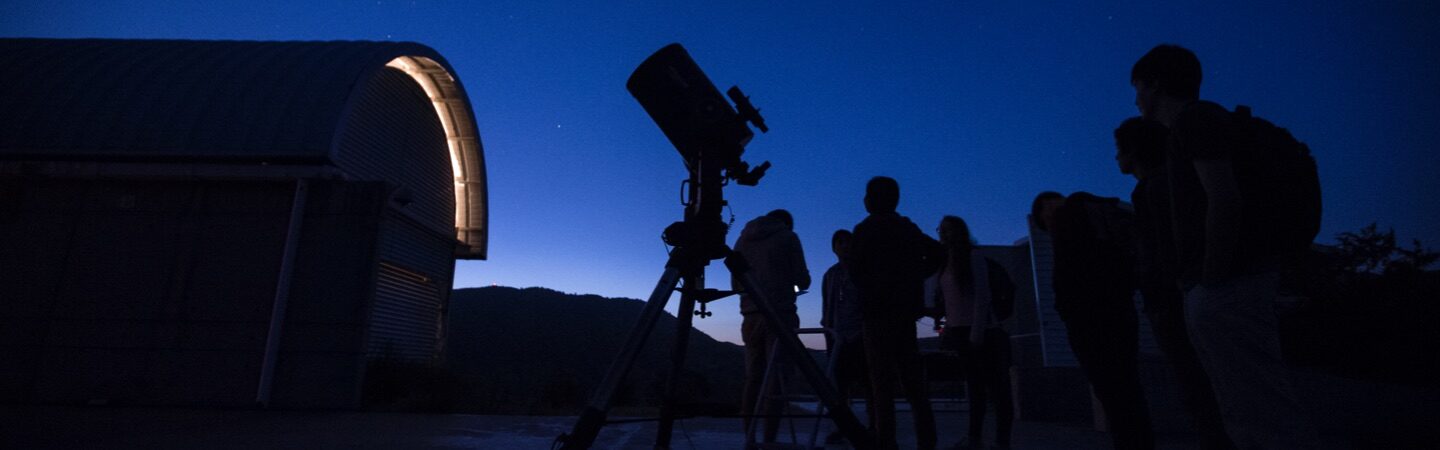 Grupo de estudiantes utilizando un telescopio.