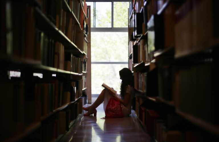 Mujer sentada en una biblioteca.