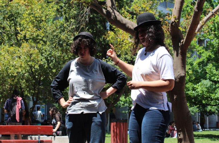 Dos personas actuando con sombreros negros.