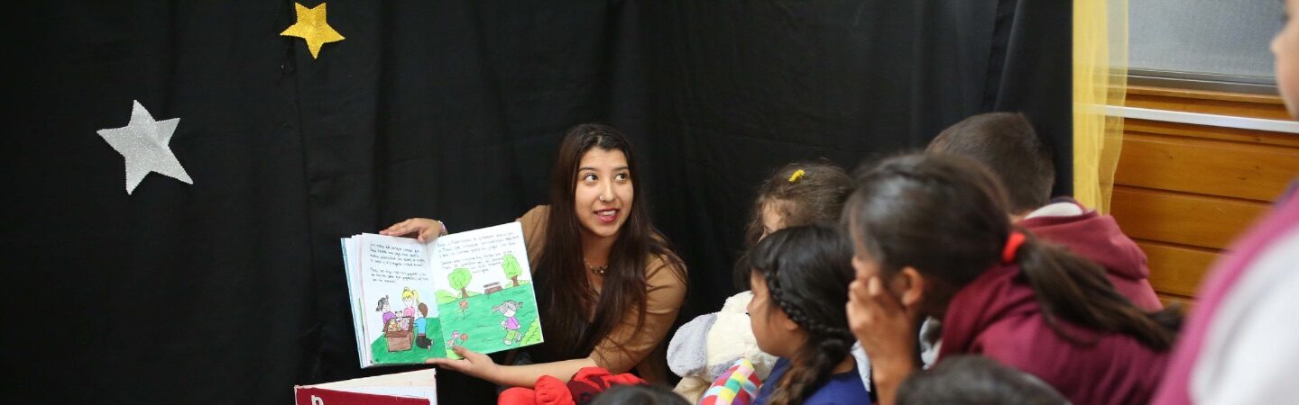 Mujer leyendo un libro de cuentos a niños.