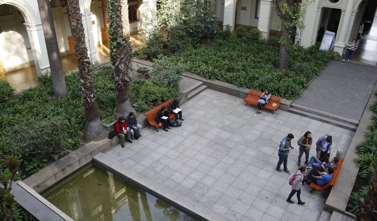 Grupo de estudiantes sentados en bancas del patio de La Virgen, vista desde arriba.